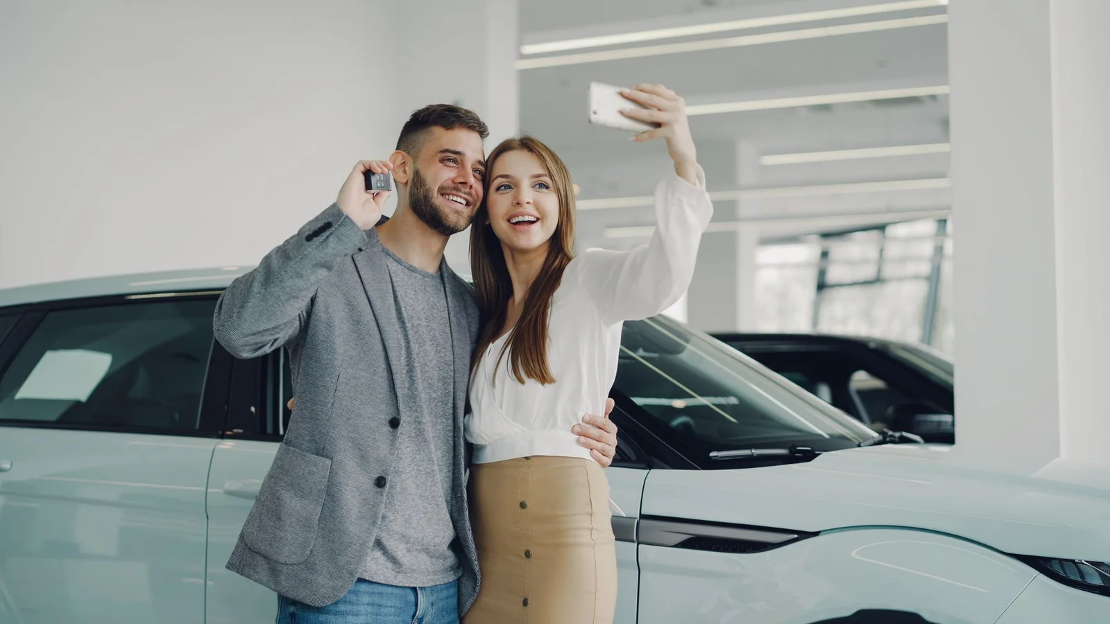 Coppia felice con le chiavi di un'auto nuova in noleggio a lungo termine senza anticipo