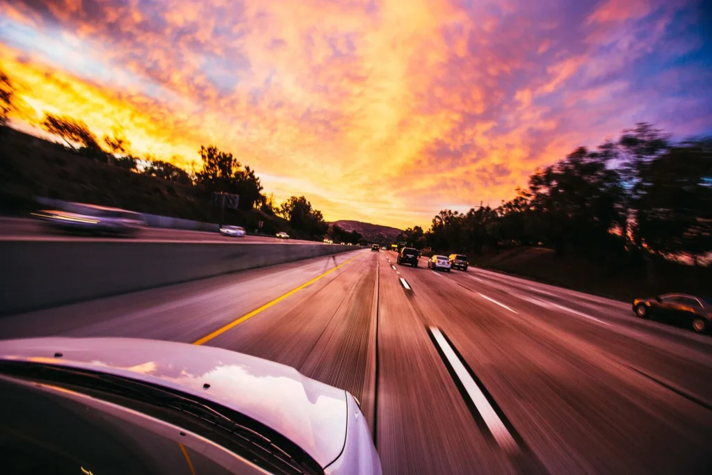 Auto in viaggio su strada al tramonto per noleggio a lungo termine